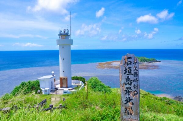 石垣島の絶景の1つ。平久保崎灯台。青空と透明度の高い海が広がる画像